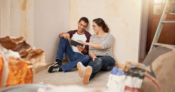 Young couple sitting on the floor in a house under construction