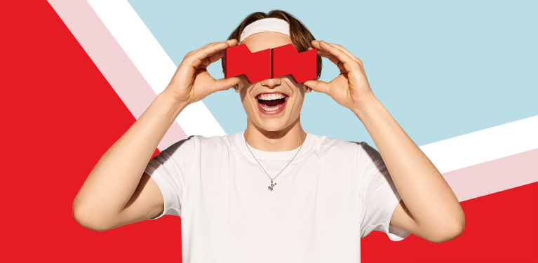 Photo of a young person holding a virtual reality headset shaped like the National Bank logo 